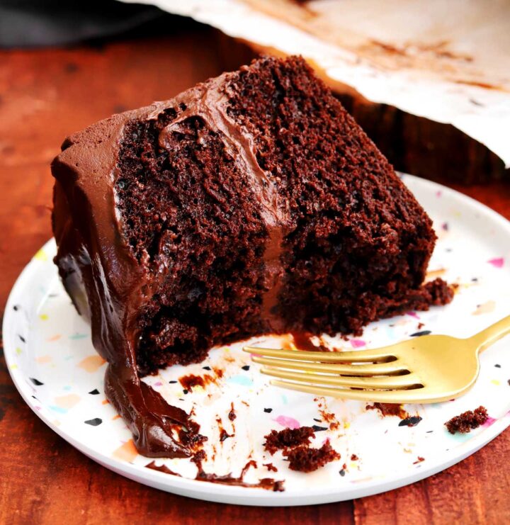 slice of best moist chocolate cake on a plate with fork and bite