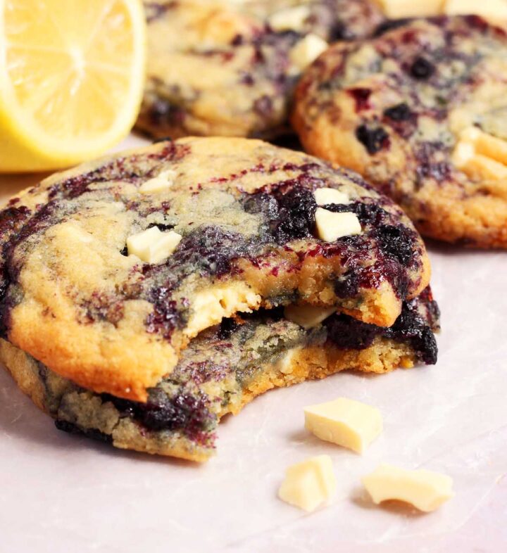 chewy lemon blueberry cookies on parchment with bite