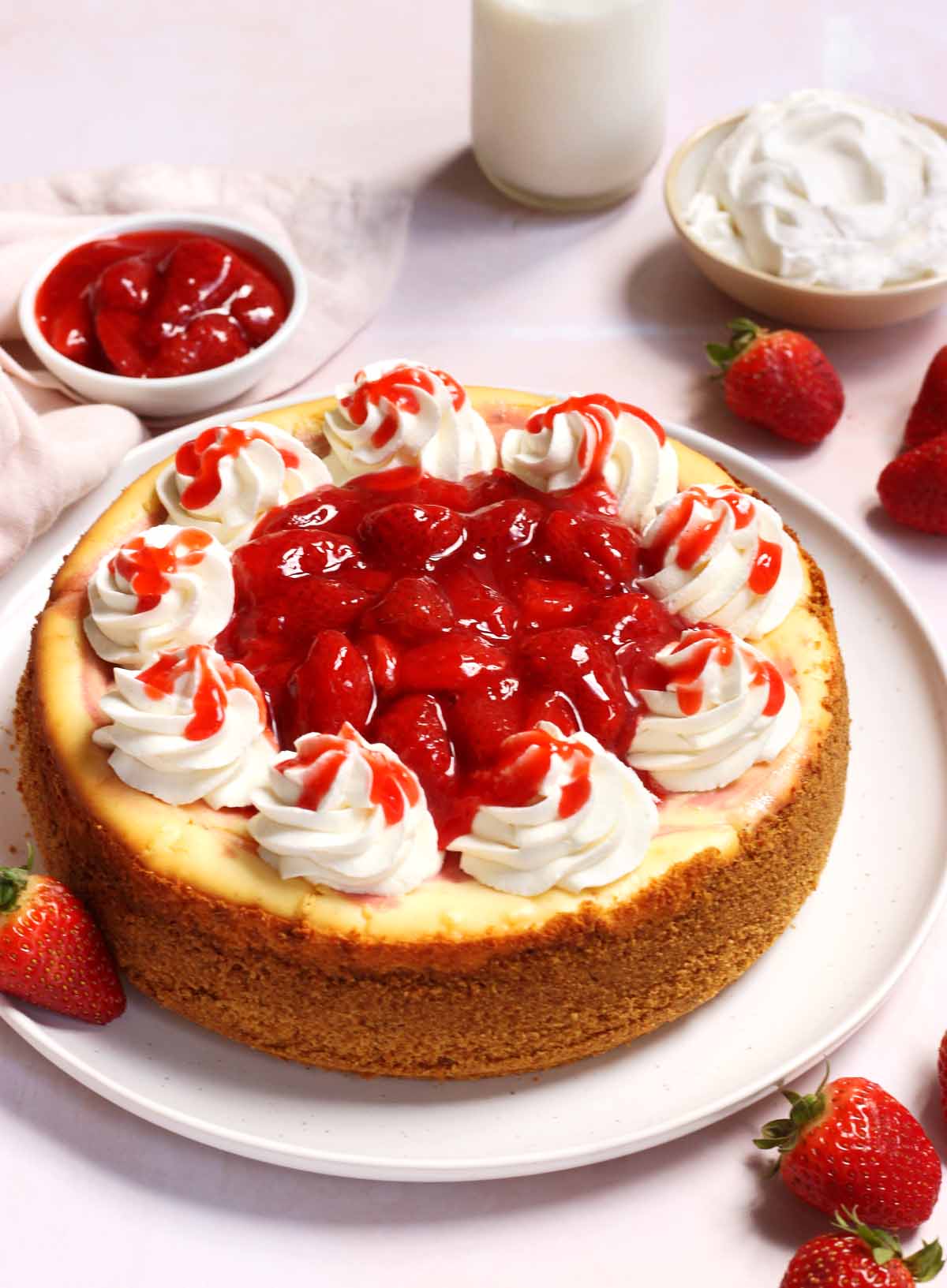 whole strawberries and cream cheesecake with whipped cream and strawberry topping