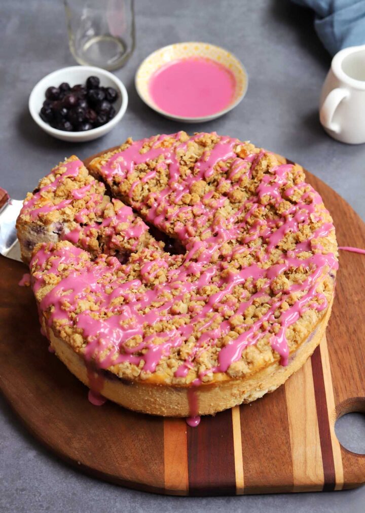 blueberry crumble cheesecake on cutting board with slice cut out