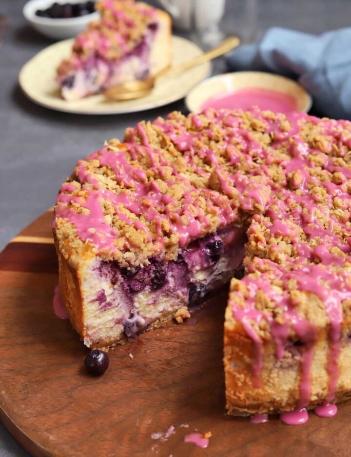 blueberry crumble cheesecake on cutting board with slice cut out