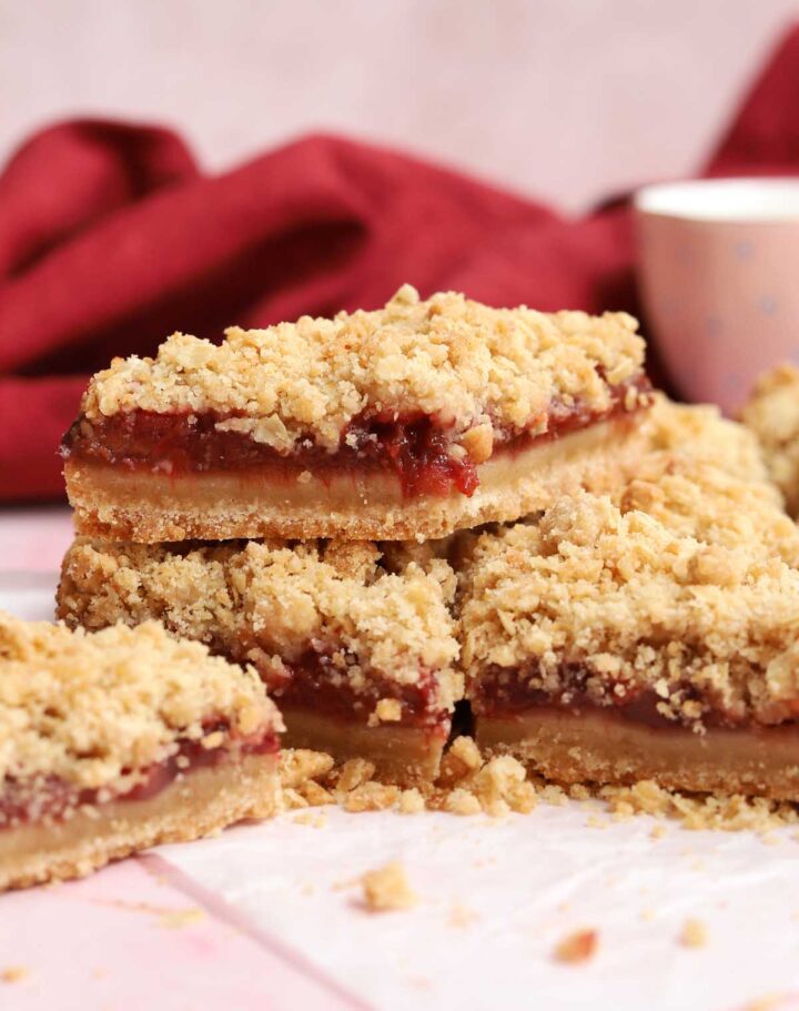 strawberry crisp bars stacked on parchment paper