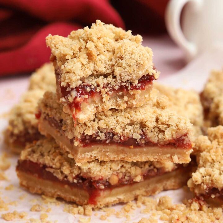 stack of strawberry crisp bars parchment paper with bite out of top bar