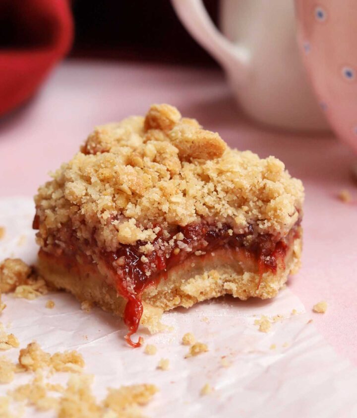 strawberry crisp bars with bite showing gooey strawberry filling