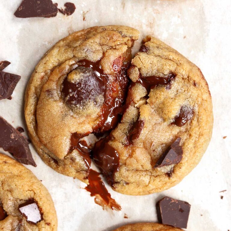 warm soft and chewy chocolate chip cookie split in half with gooey middles and melted chocolate