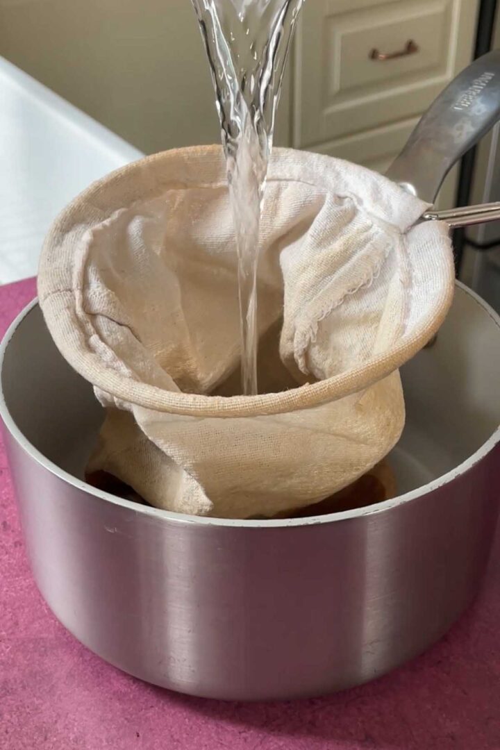 pouring hot water over Thai tea leaves in tea sock
