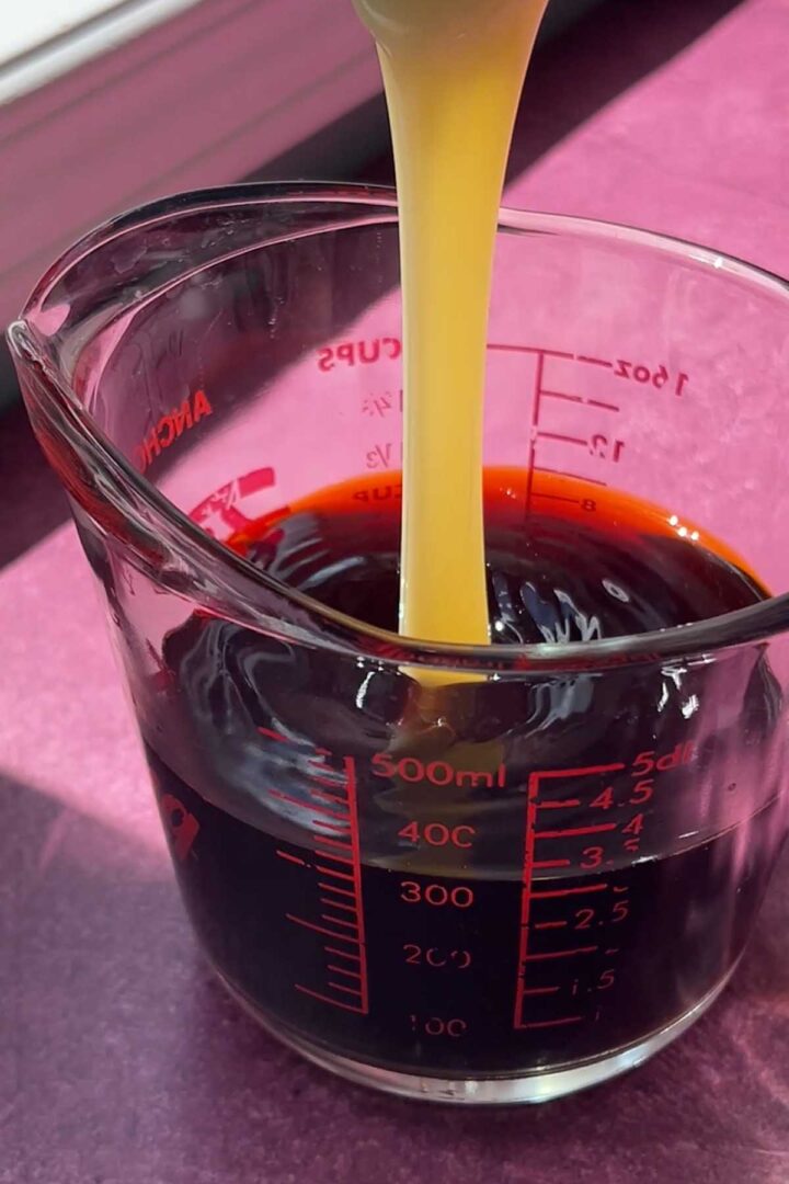 adding sweetened condensed milk to brewed Thai tea
