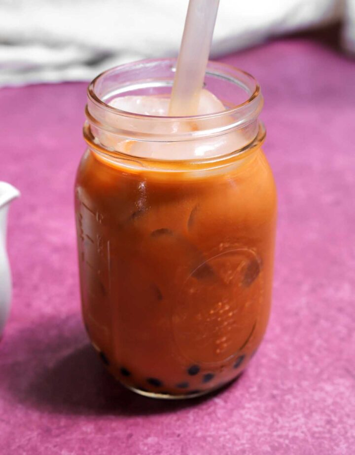 Thai tea bubble tea in mason jar with boba straw
