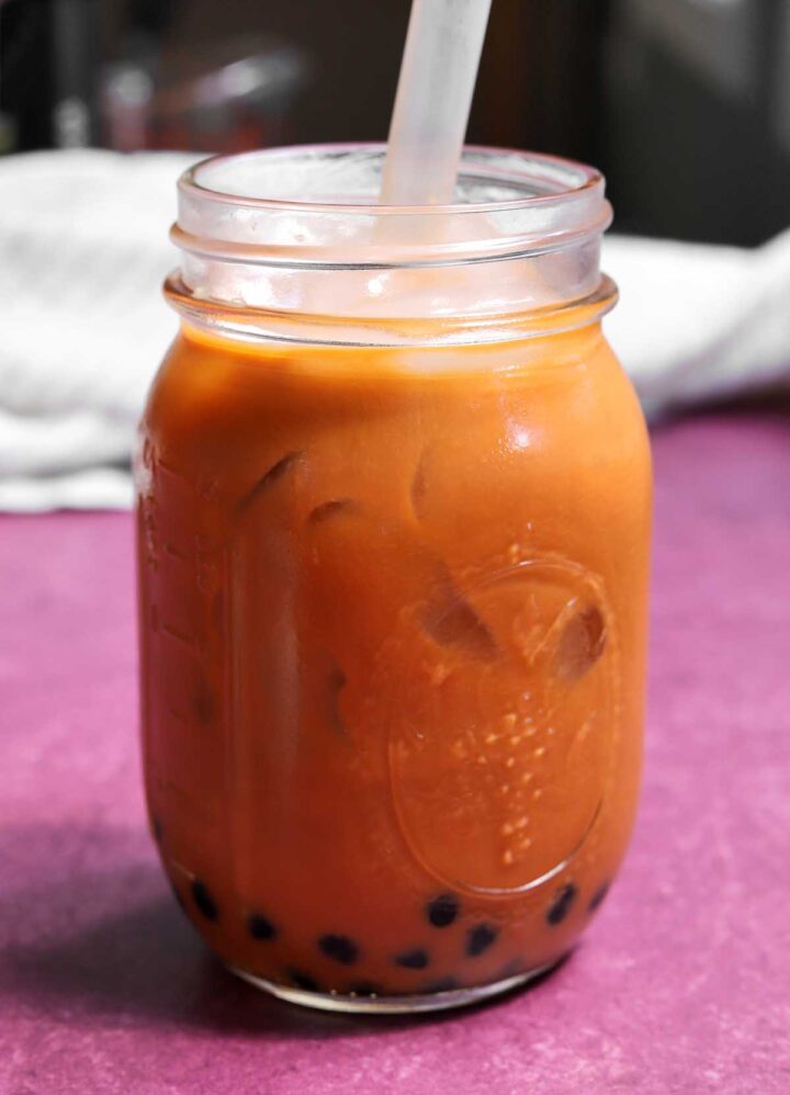 Thai tea bubble tea in mason jar with boba straw
