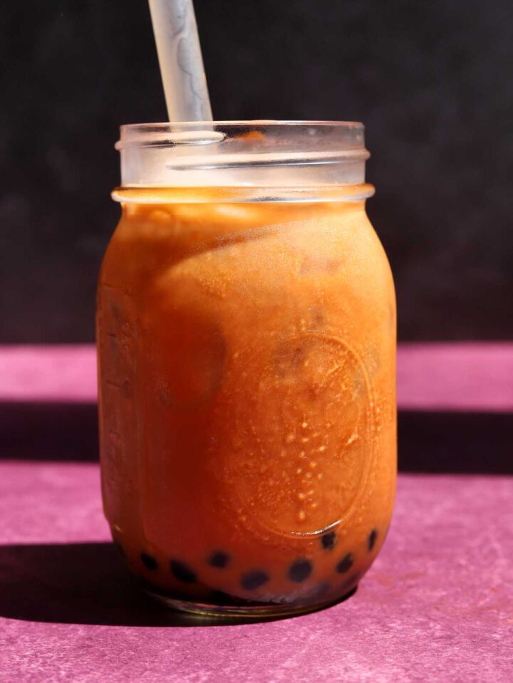 Thai tea bubble tea in mason jar with boba straw