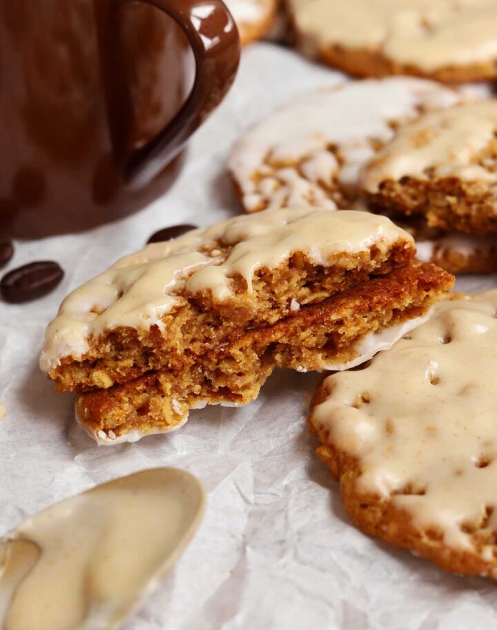 pumpkin spice latte iced oatmeal cookies broken in half showing chewy center
