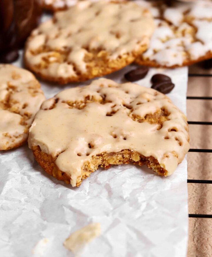 pumpkin spice latte iced oatmeal cookie on cooling rack with bite