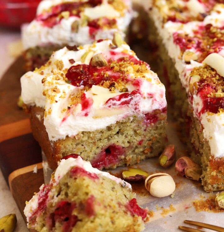 raspberry pistachio cake sliced on cutting board