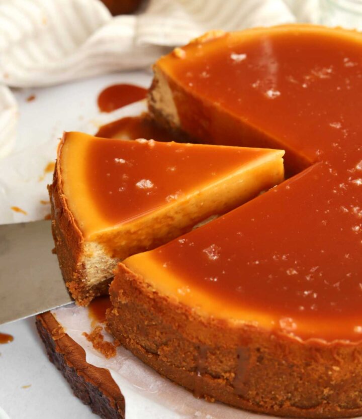 angle view of sliced salted caramel cheesecake with slice coming out