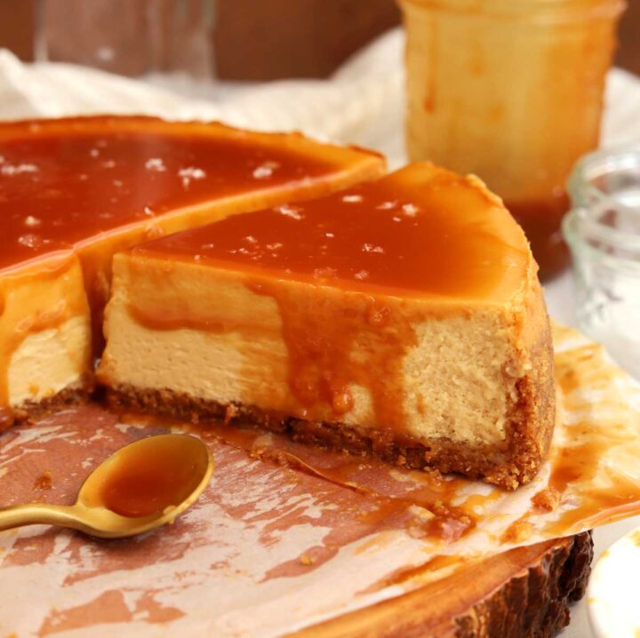 angle view of sliced salted caramel cheesecake with slice coming out