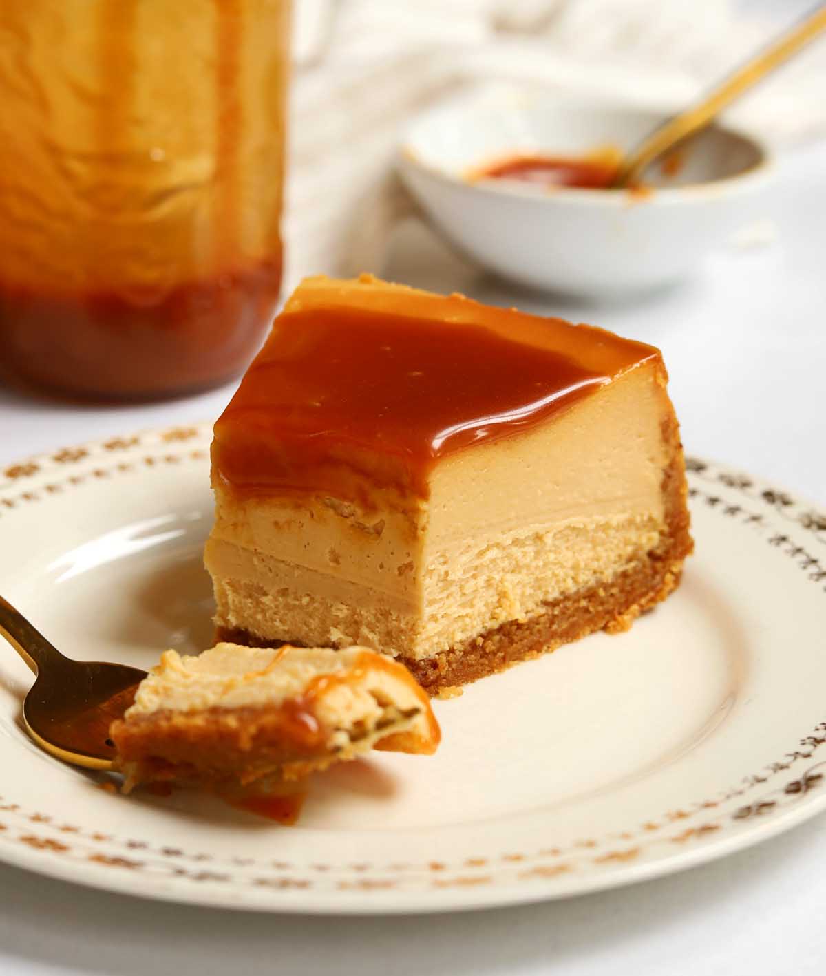 slice of salted caramel cheesecake on a plate with bite and fork