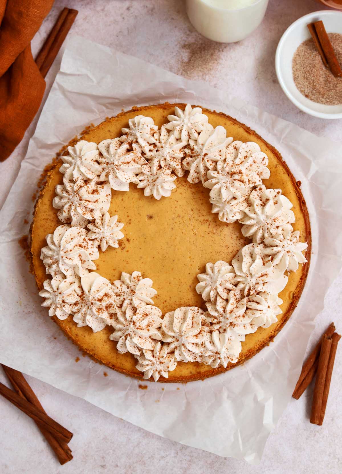 top view of cinnamon swirl pumpkin cheesecake with whipped cream topping
