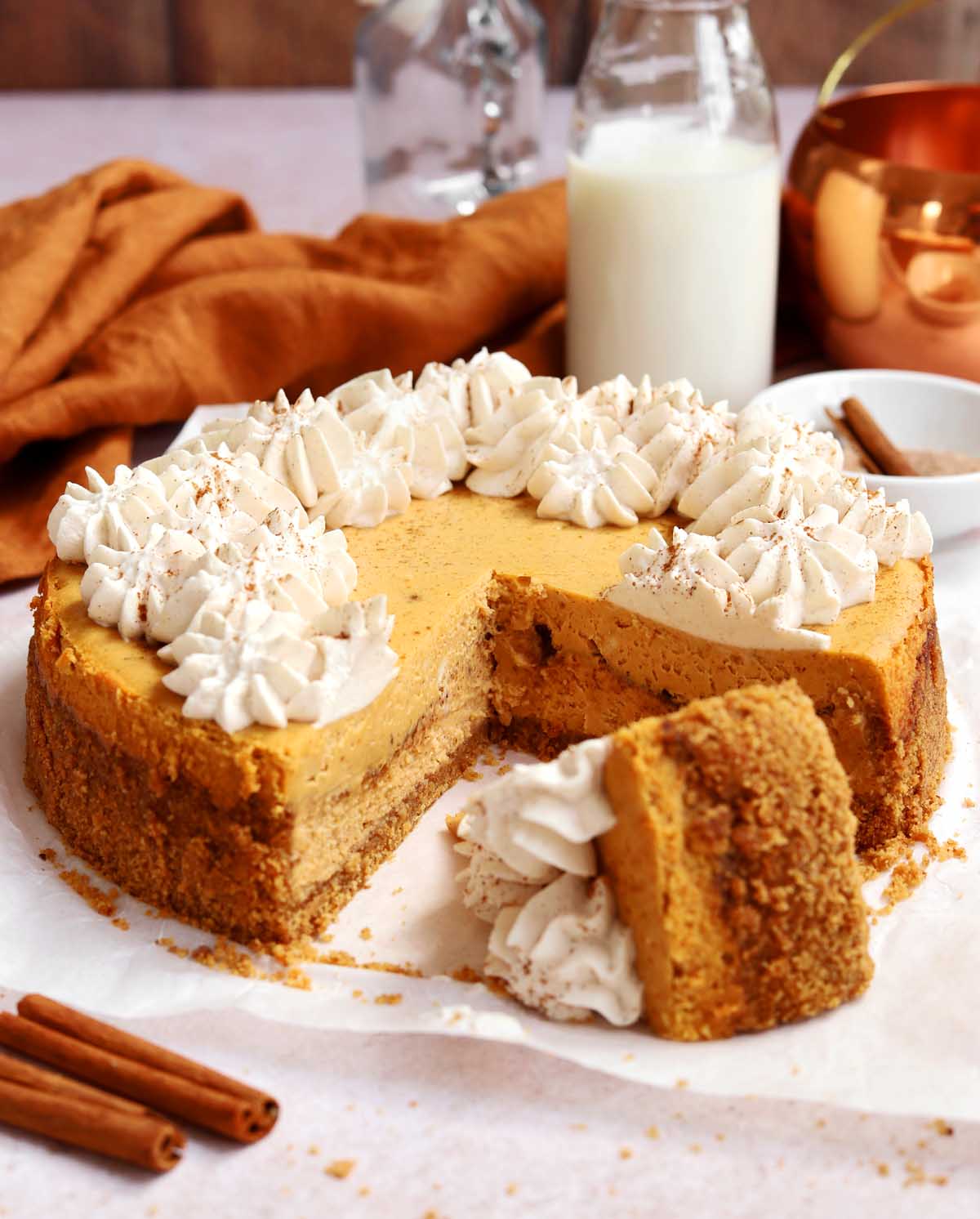 cinnamon swirl pumpkin cheesecake with slice cut out