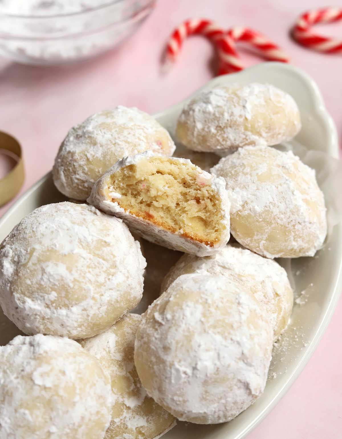 peppermint snowball cookies in a serving dish with bite showing tender insides