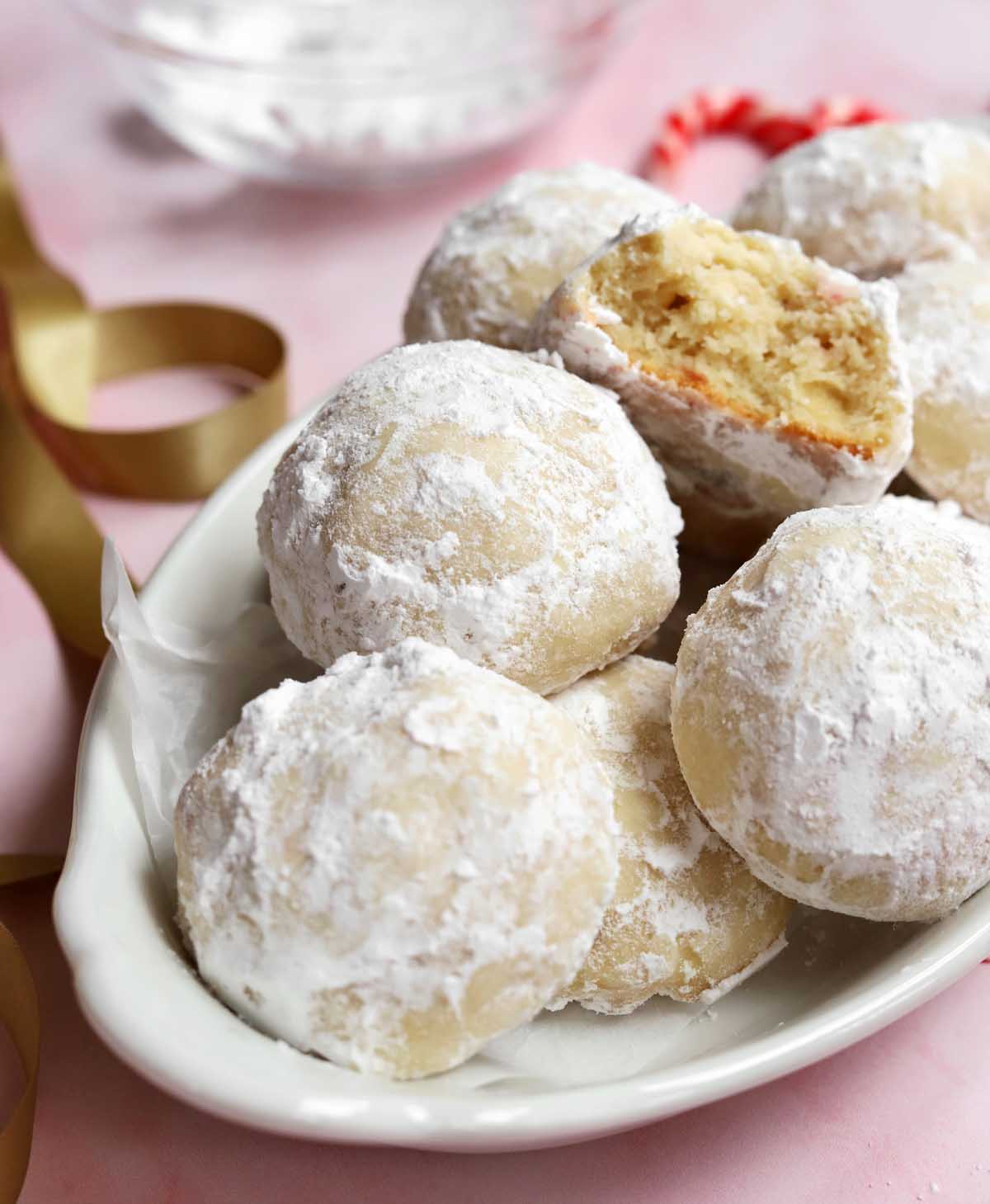 peppermint snowball cookies in a serving dish with bite showing tender insides