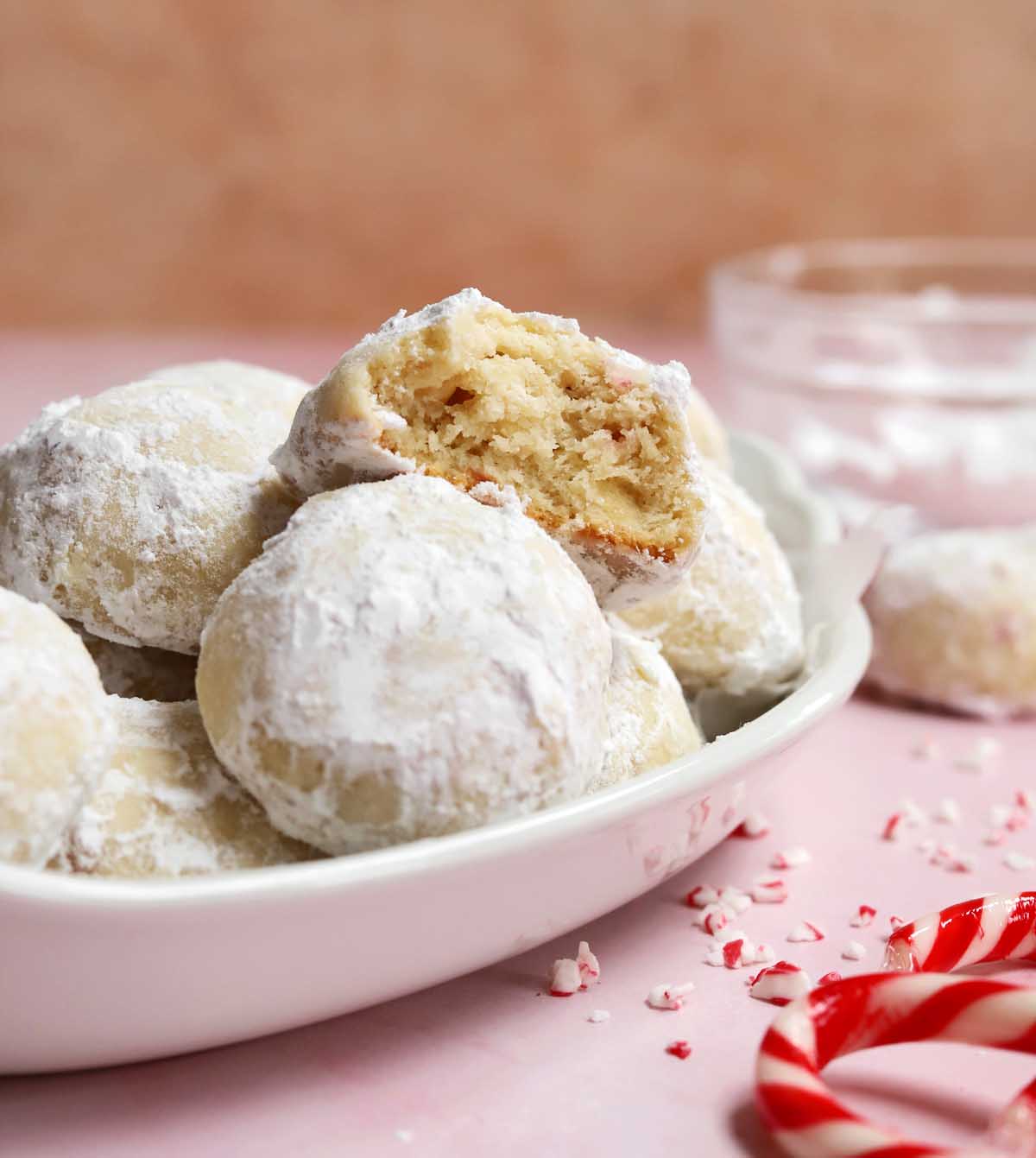 peppermint snowball cookies in a serving dish with bite showing tender insides