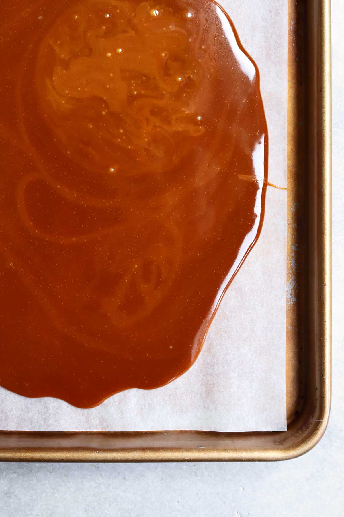 close up on homemade toffee after setting on a lined baking sheet to set