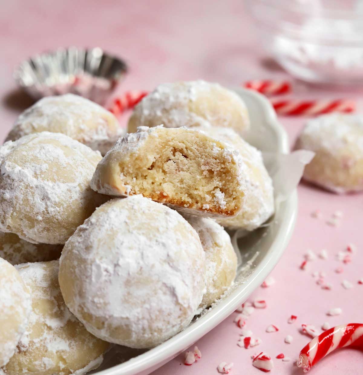 peppermint snowball cookies in a serving dish with bite showing tender insides