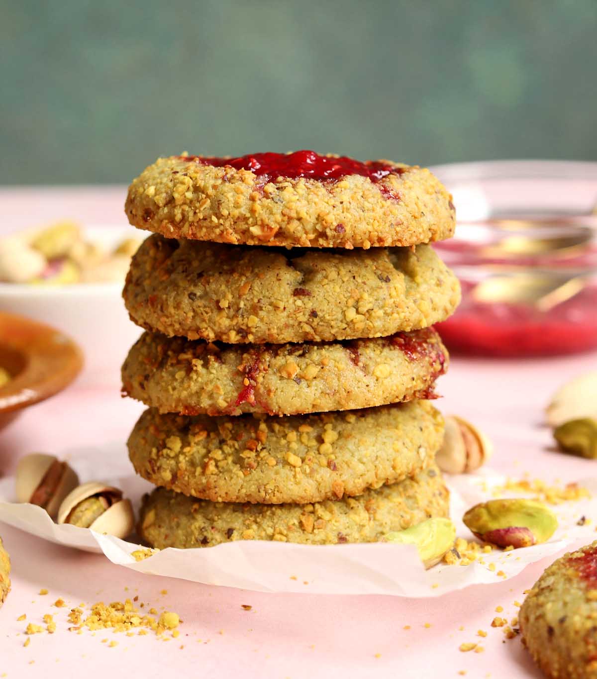 stack of raspberry pistachio thumbprint cookies