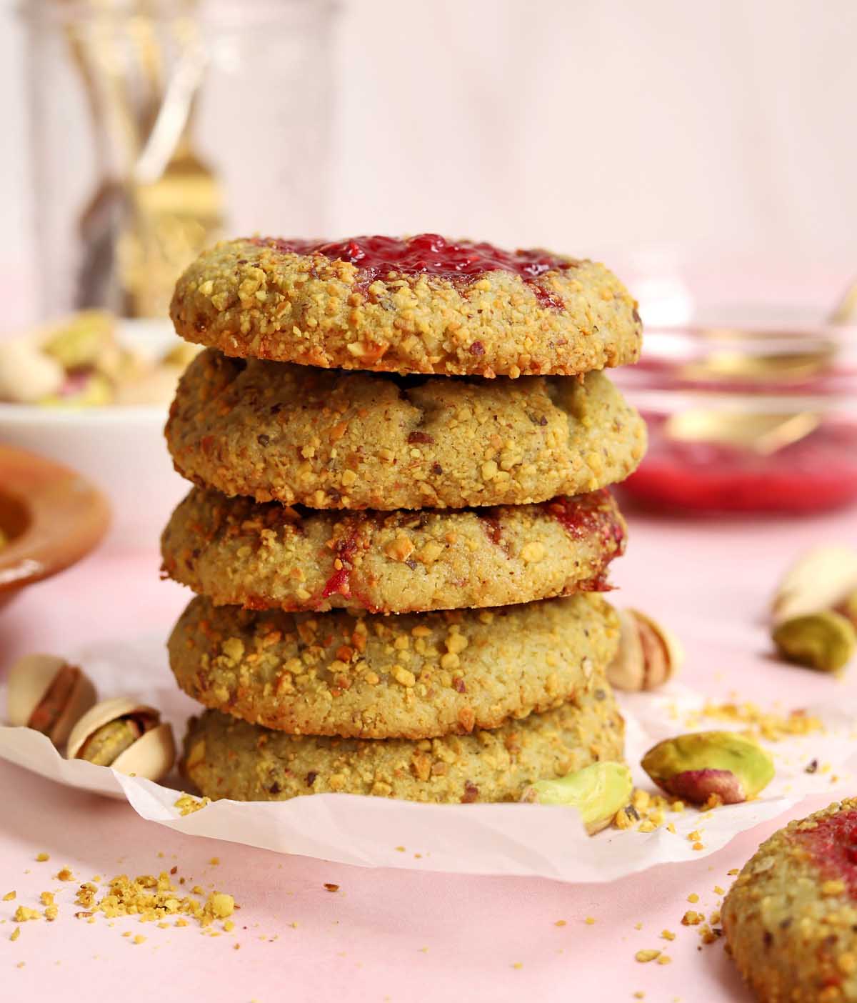 stack of raspberry pistachio thumbprint cookies