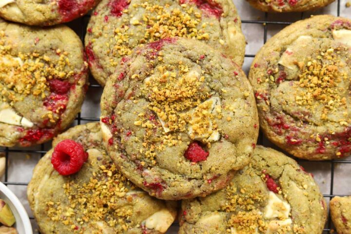 top view of white chocolate raspberry pistachio cookies on cooling rack over baking sheet