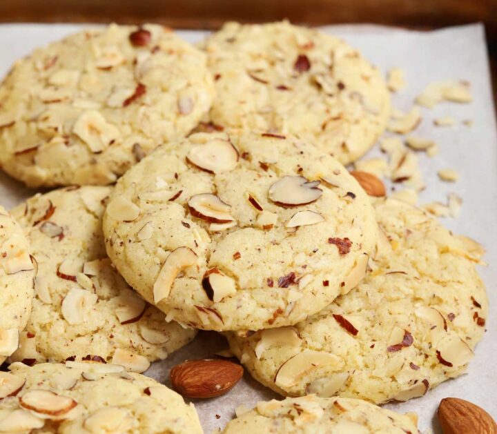 lemon almond cookies piled up on baking sheet