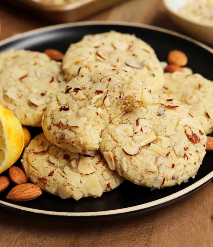 lemon almond cookies on a plate with bite