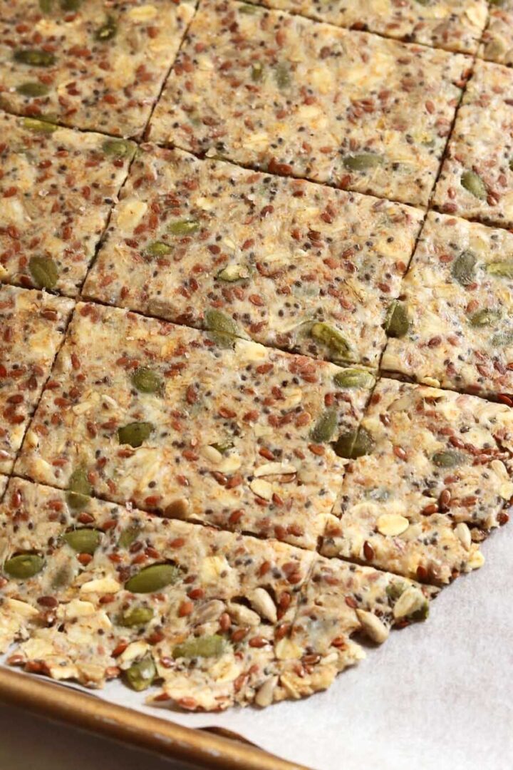 super seed cracker dough rolled out thinly on parchment