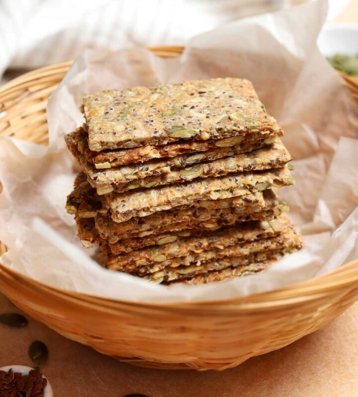 homemade super seed crackers stacked up in a bread basket
