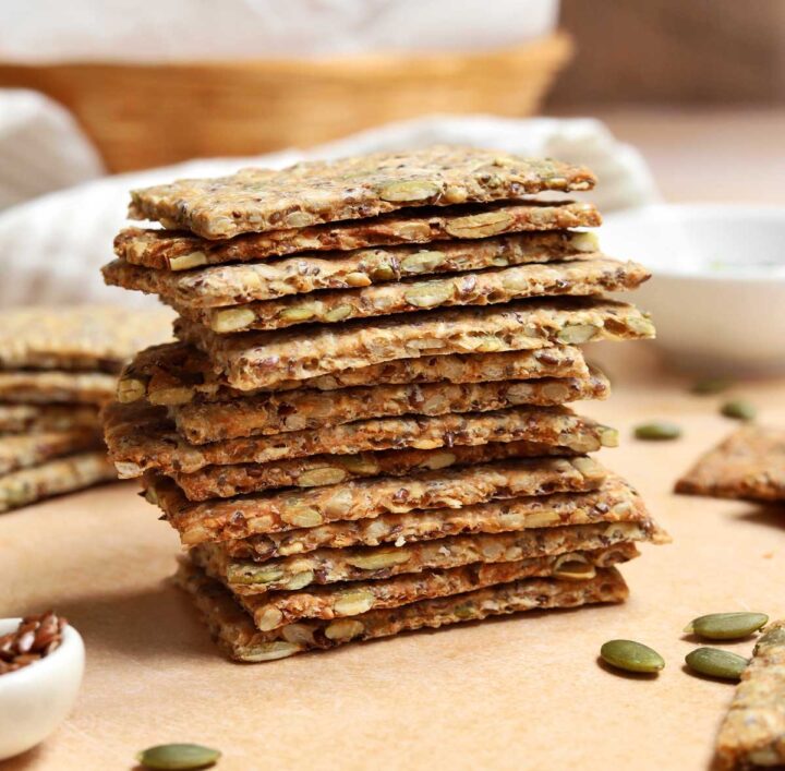 super seed crackers stacked on a cutting board