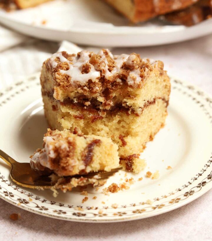 sour cream coffee cake slice on plate with bite on a fork