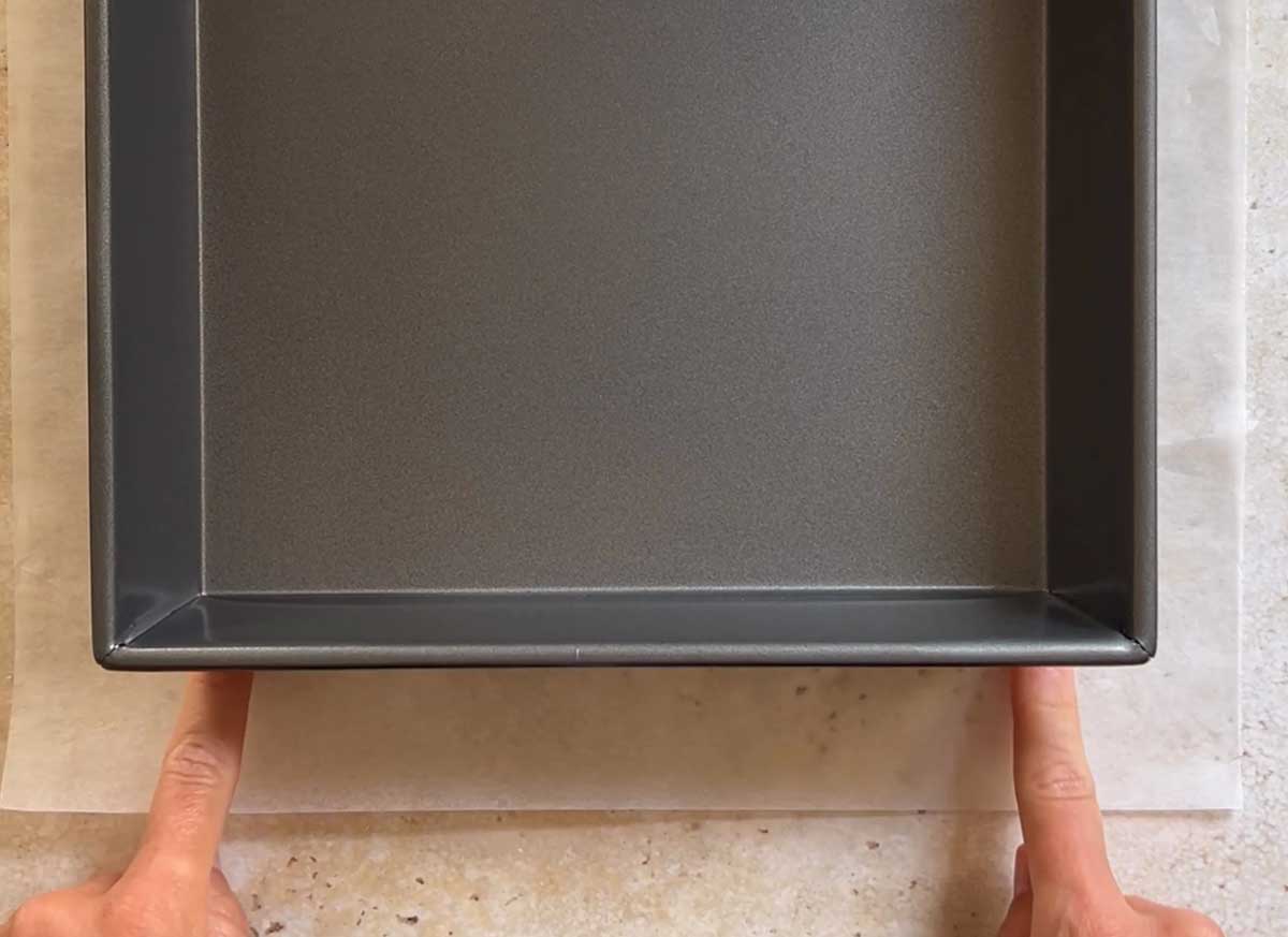 Place the baking pan over the parchment paper so it is centered.