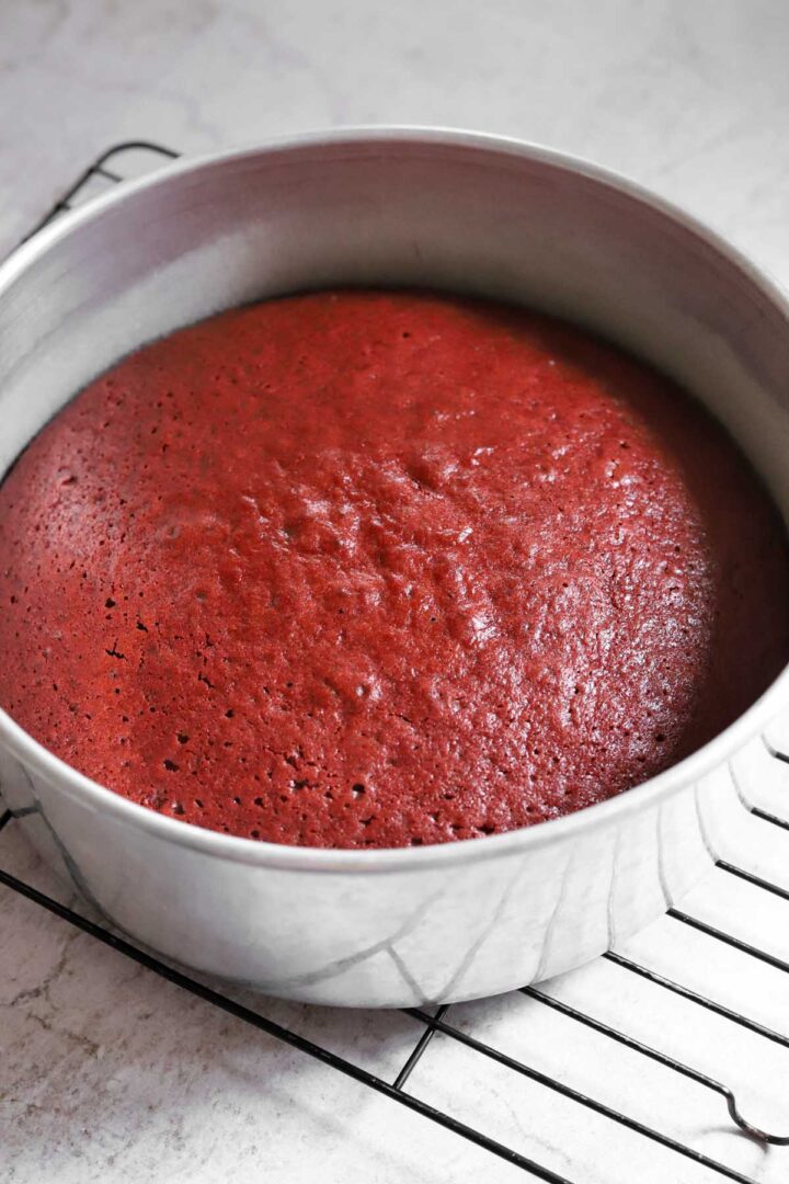 baked red velvet cake in pan on cooling rack
