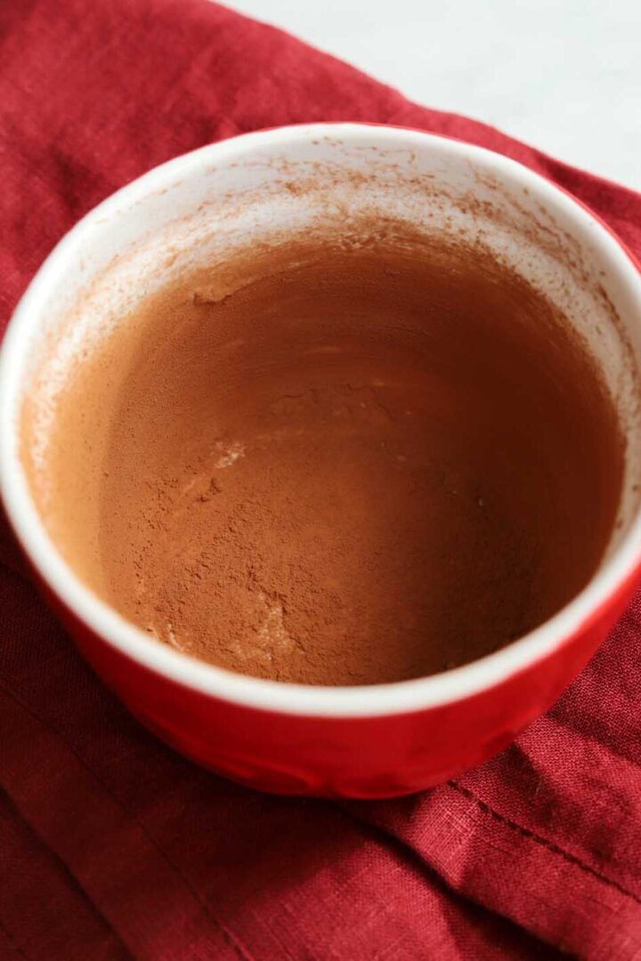 buttered and cocoa-dusted ramekin prepared for molten chocolate lava cake batter