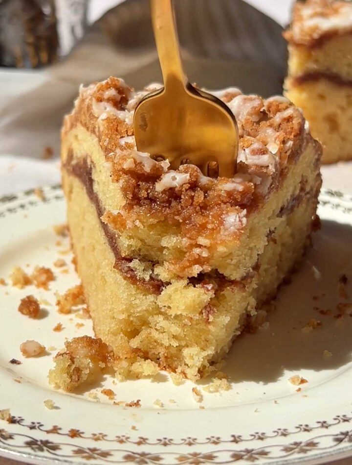 slice of sour cream coffee cake on a plate with fork to take a bite