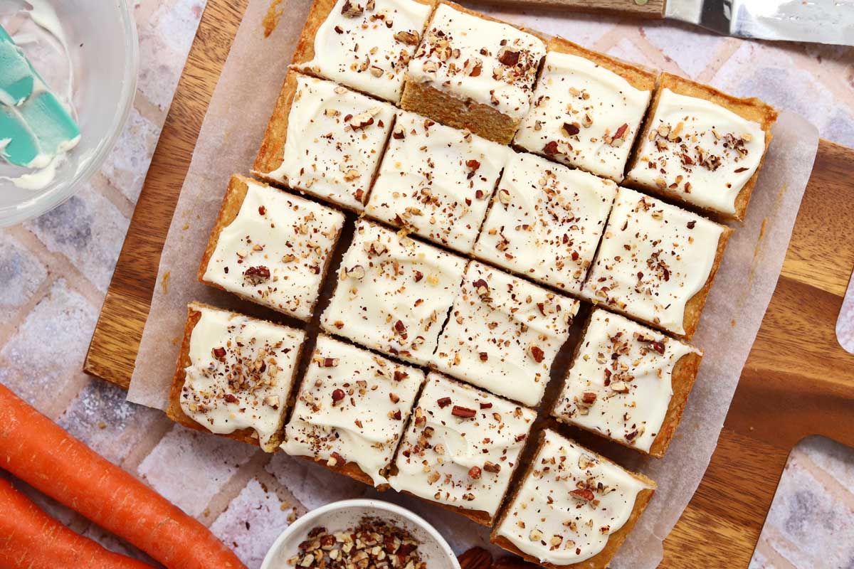sliced carrot cake bars with cream cheese frosting and toasted pecans
