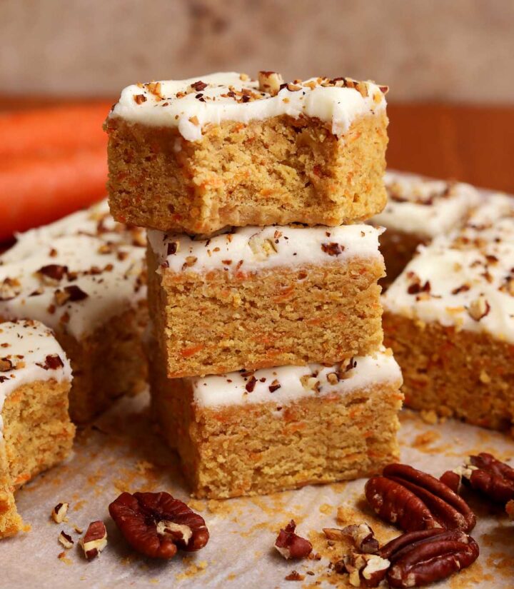 stack of carrot cake bars with bite on cutting board