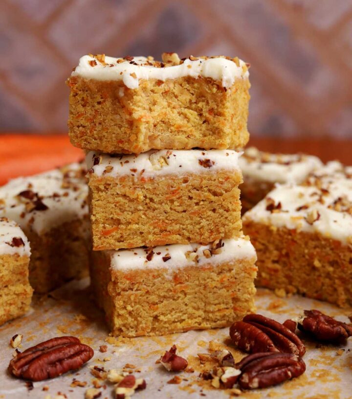 stack of carrot cake bars with bite on cutting board