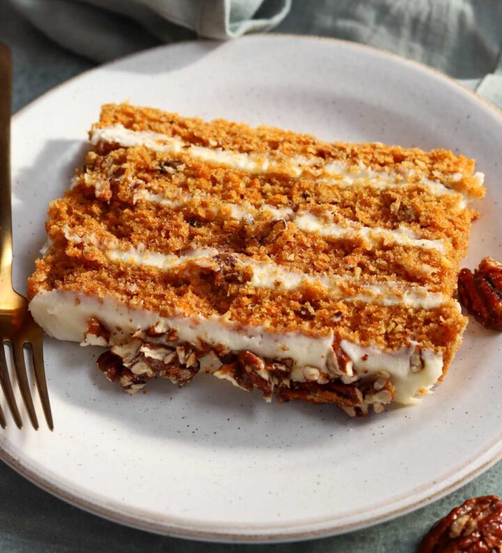 slice of praline crunch carrot cake layer cake on a plate
