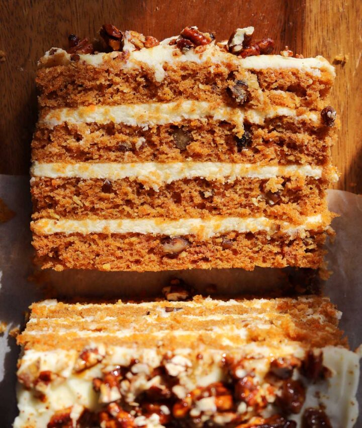 praline crunch carrot cake layer cake on a cutting board sliced showing the cross section of all 4 layers