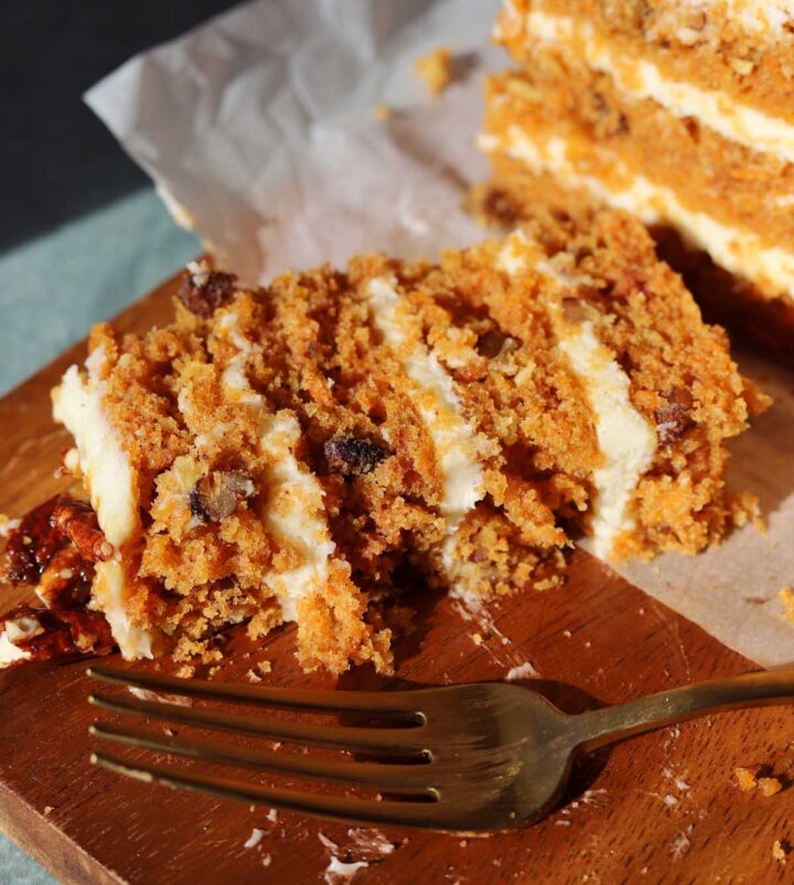praline crunch carrot cake layer cake on a board with with fork