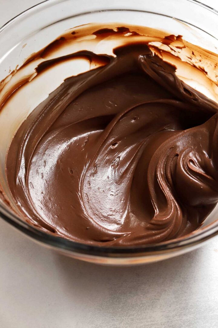 whipped milk chocolate frosting in a bowl with spatula