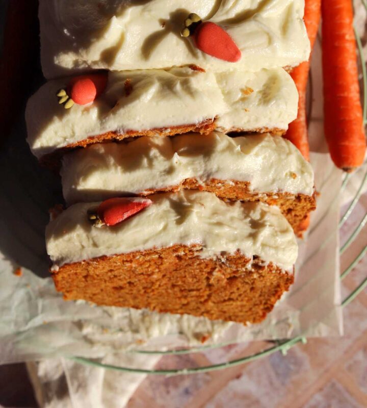 top view of sliced carrot cake loaf cake on cooling rack with cream cheese frosting