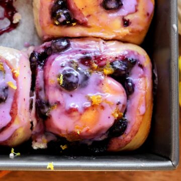 close up of lemon blueberry sweet rolls in baking pan