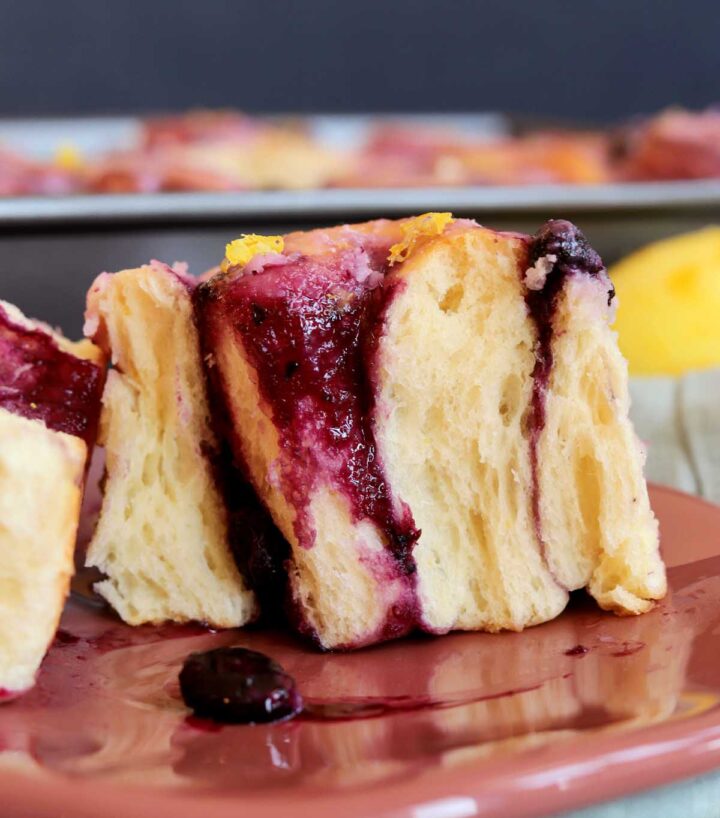 lemon blueberry sweet roll split in half on a plate
